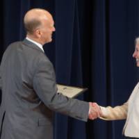 Dean Potteiger shaking hands with woman receiving an award